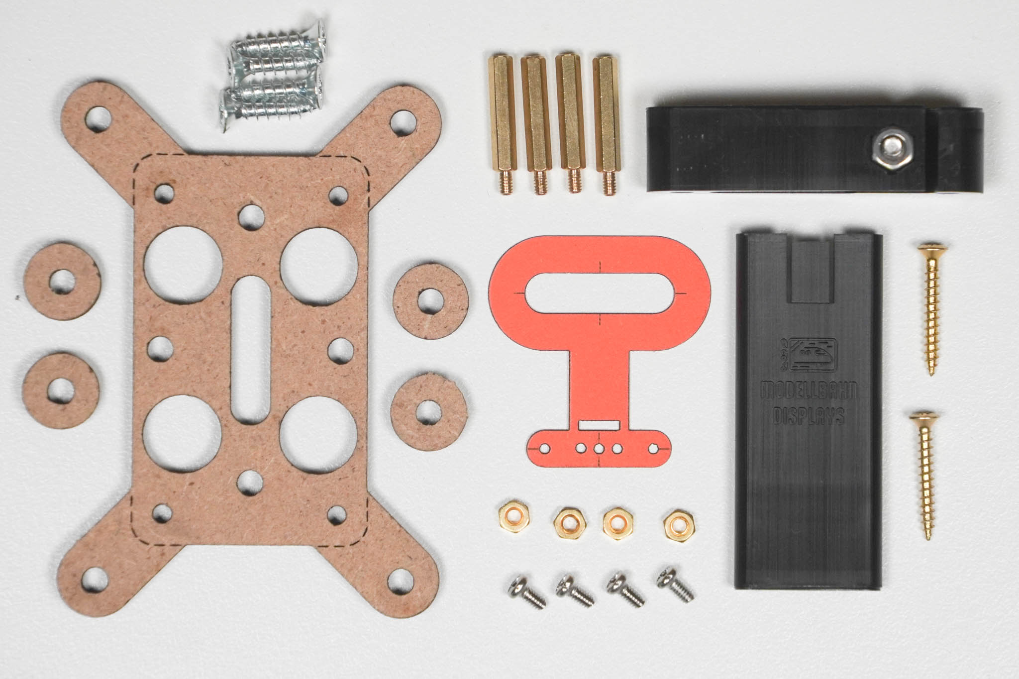 Alle Teile des Montagekits nebeneinander ausgelegt — Controller-Halter aus MDF, Schrauben, Abstandshalter, Muttern, Abstandsringe, Anzeichenhilfe, Schiene und Schienenfixierung