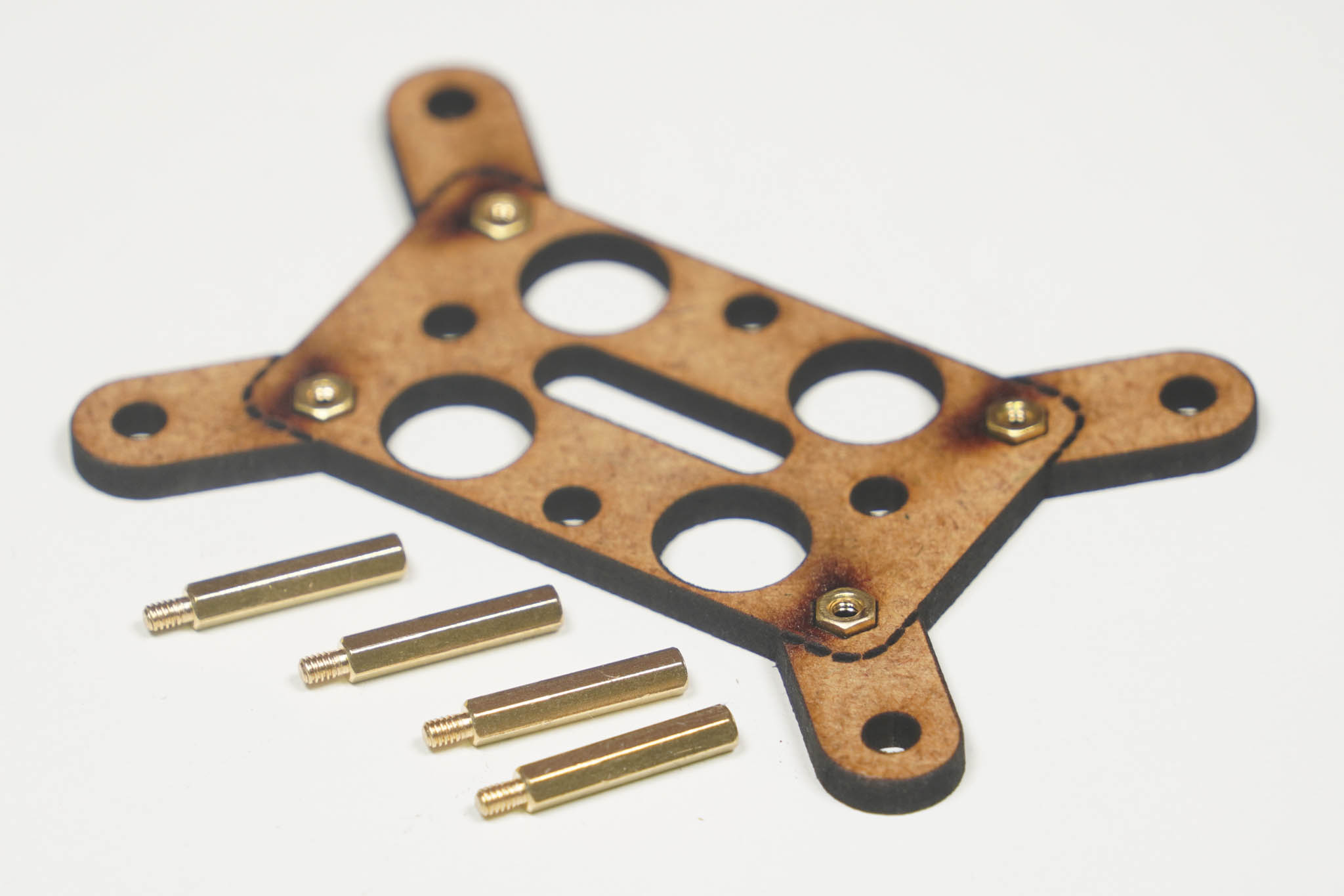 Controller-Halter mit eingesetzten Muttern, daneben die vier Messing-Abstandshalter