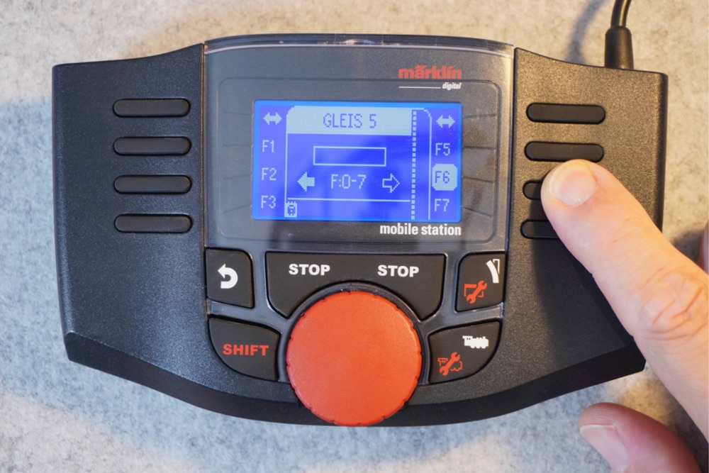Das Fahrpult der mobile station mit der virtuellen Lok „GLEIS 5" und den Funktionstasten F1 bis F7; ein Finger drückt F6